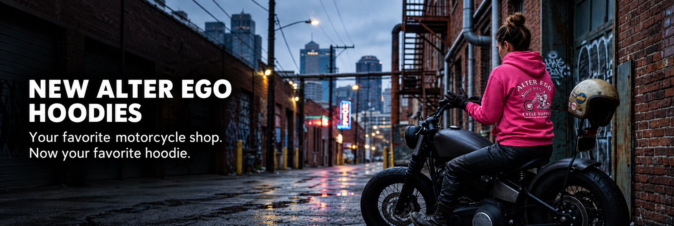 New Alter Ego hoodies. Your favorite motorcycle shop. Now your favorite hoodie. A rider wears the pink hoodie on a motorcycle in a city alley.